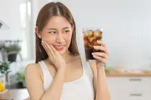 Young woman experiencing teeth sensitivity after whitening treatment